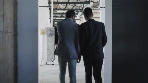 Colleagues enter the office space in a loft style, fit and sit at the table Stock Footage 109556893
