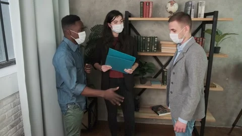 Colleagues in face masks avoid a handshake using santizer when meeting in the Video stock 141947966