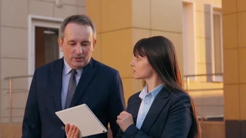 Colleagues focus on modern tablet displaying graph of business growth walking Stock Footage 255749547