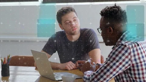 Colleagues gesturing at laptop sparking data overlay showing business analysis Stock Footage 318545529