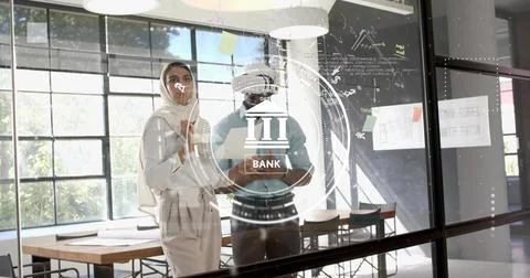 Colleagues interacting with banking interface on glass wall in meeting room with Stock Photos