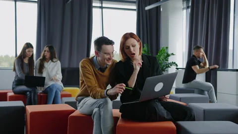 Colleagues with a laptop work sitting in open space. Brainstorming, mall startup Stock Footage 236986882