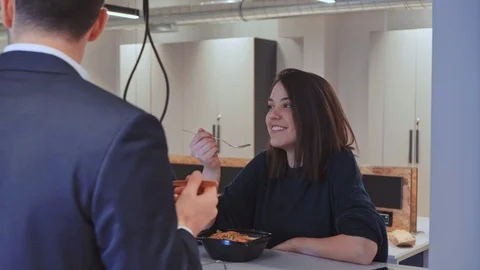 Colleagues laughing while eating in the office cafeteria Stock Footage 102214233