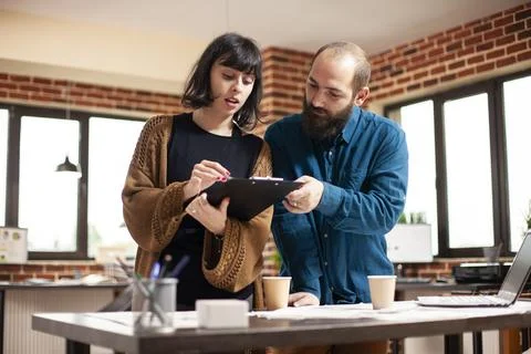 Colleagues looking at data on clipboard Stock Photos