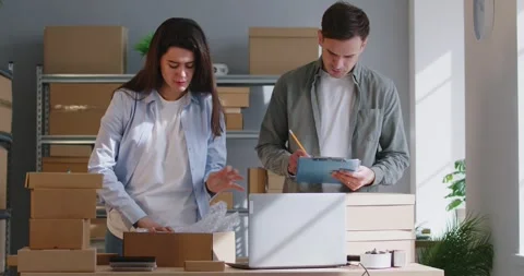 Colleagues Packing Parcels In Cardboard Boxes For Warehouse Shipment Video stock 283915790