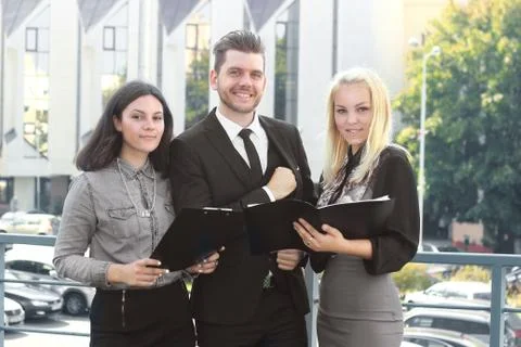 Colleagues reading documents standing on the balcony of the office Stock Photos