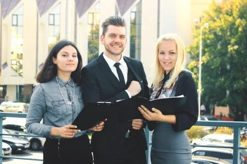 Colleagues reading documents standing on the balcony of the office Stock Photos