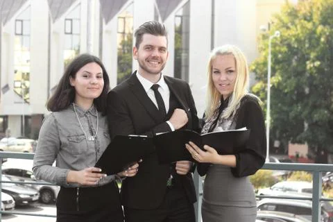 Colleagues reading documents standing on the balcony of the office Stock Photos