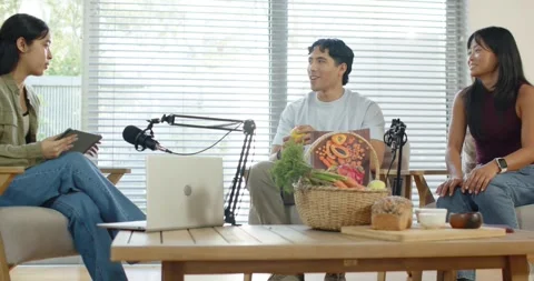 Colleagues recording as host entering, gesturing tablet while guest holding Stock Footage 335906960