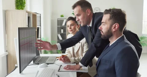 Colleagues reviewing data spreadsheet discussing strategy at workstation Stock Footage 328139743