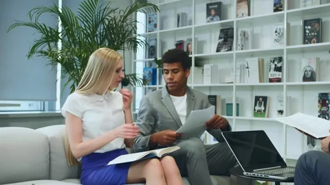 Colleagues Reviewing Documents and Laptop in Modern Office Warsaw Stock Footage 340265722