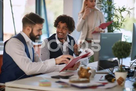 Colleagues sharing plan, report, data, stats, content in the office at work. Stock Photos