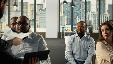 Colleagues sharing reports and visual data on computer in office Stock Photos