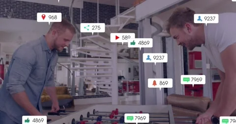 Colleagues spinning table rods, igniting social media icons pulsing, visualizing Stock Footage 319573662