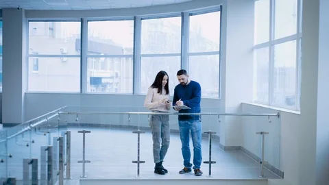 Colleagues stand in a spacious office building and discuss the project, actively Stock Footage 122599542
