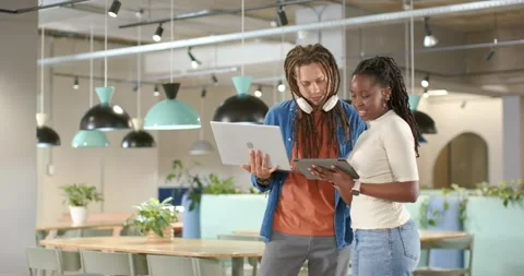 Colleagues starting project review in co-working space, leaning, tapping tablet, Stock Footage 335131308