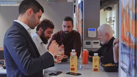 Colleagues taking a lunch break in the office cafeteria Stock Footage 102214403