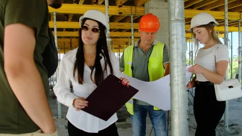 Colleagues talk about work process looking at floor plan Stock Footage 317608359