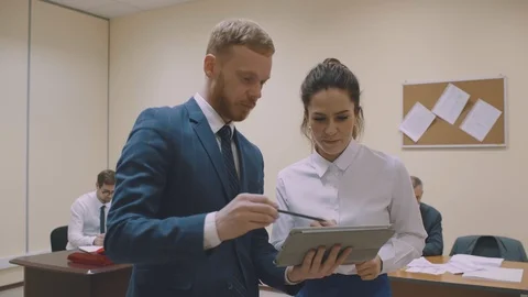 Colleagues talking about strategy with tablet PC. Office workers having informal Stock Footage 124691968
