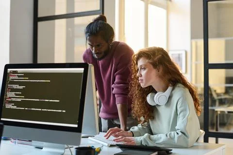 Colleagues typing computer codes together Stock Photos