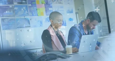 Colleagues typing at table, data sync causing HUD overlays over laptops showing Stock Footage 326974779