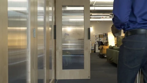Colleagues walking through door in office space. 스톡 동영상 88025413