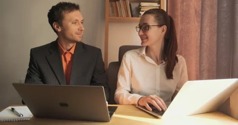 Colleagues work at computer on same desktop in home office. They smile and give Video stock 201878219