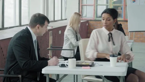 Colleagues work in the office space. A female employee drives up to the manager Stock Footage 124548213