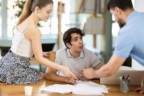 Colleagues work on paper drawing, making sketches while discussing construction Stock Photos