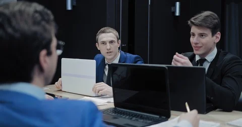 Colleagues at work talk in the meeting room. Businessmen are discussing company Stock Footage 102479656