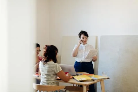 Colleagues working on project around table Stock Photos