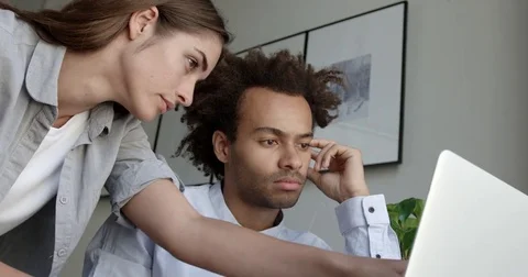 Colleagues working on a project discussing design decisions looking concentrated Stock Footage 82677259