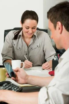 Colleagues working at the same desk 写真素材