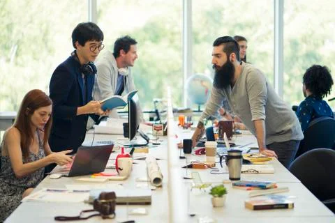 Colleagues working together in open plan office Stock Photos