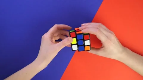 Collect the Rubik's Cube. Top view male caucasian hands collect the same colors Stock Footage 171774412