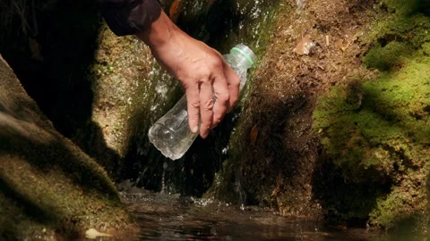 Collect water from a mountain spring into a bottle. Ecologically clean cold.. Vidéo 296060030