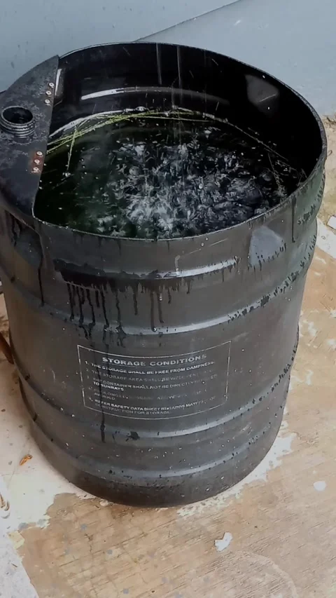 Collecting clean rainwater while raining from roof top into black container. Stock Footage 315544857
