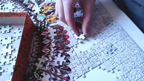 Collecting puzzles. the fitted part is placed by hand in place for the drawing Stock Footage 196835222