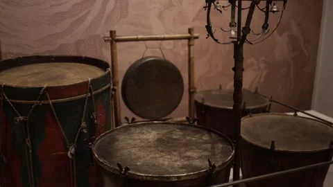 A collection of antique percussion instruments, including drums and a gong, disp Stock Footage 293565813