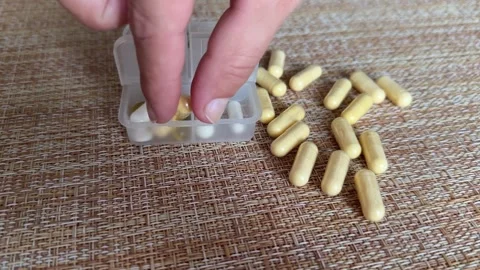 A collection of assorted capsules along with a convenient pill organizer for Stock Footage 316391303