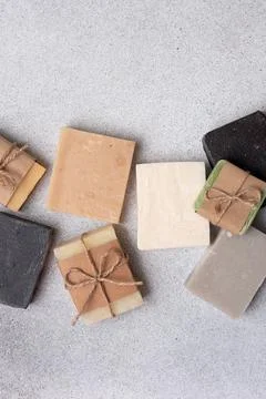 A collection of assorted handmade soap bars on grey concrete background. Sust 库存照片