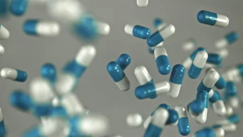 Collection of blue and white capsules displayed on gray surface Filmed on a high Stock Footage 335424126