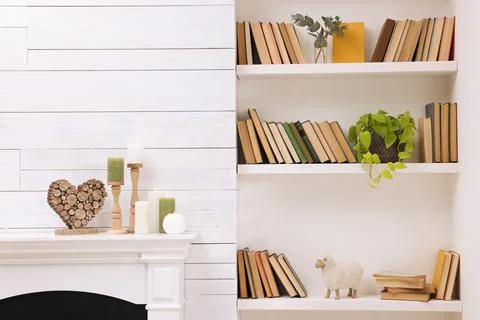 Collection of books and decor elements on shelves indoors 库存照片