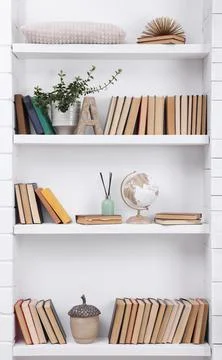 Collection of books and decor elements on shelves indoors 库存照片