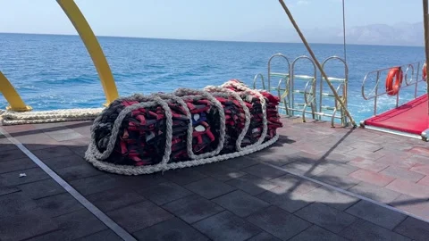 A collection of bright red life jackets is scattered on a wooden deck. Stock Footage 297964741