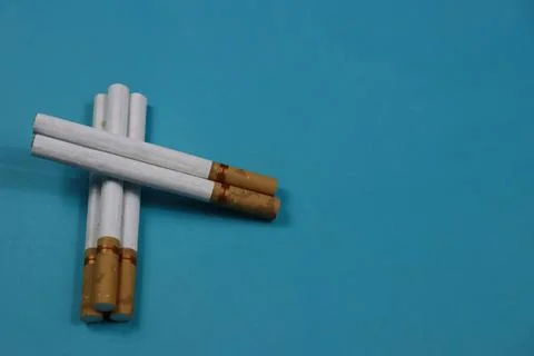 A collection of cigarettes arranged on a blue background Stock Photos