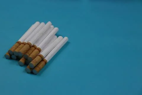 A collection of cigarettes arranged on a blue background Stock Photos