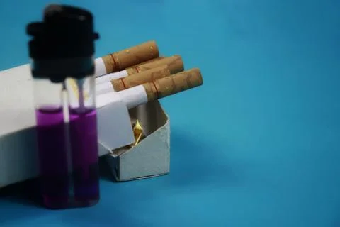 A collection of cigarettes arranged on a blue background Stock Photos