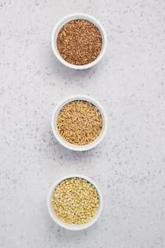 Collection of different groats on grey background. Top view of buckwheat, chia Stock Photos