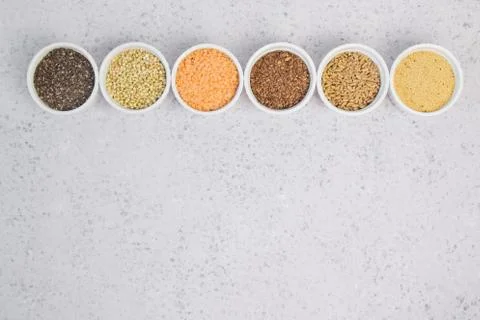 Collection of different groats on grey background. Top view of buckwheat, chia Stock Photos